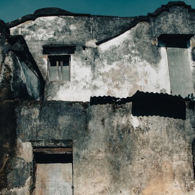 Bức ảnh chụp một bức tường cổ kính với kết cấu thời gian rõ nét và ánh sáng tự nhiên chiếu lên. Tổng thể tạo cảm giác hoài niệm và truyền thống đặc trưng của phố cổ Hội An.