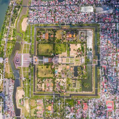 Ảnh chụp toàn cảnh từ trên cao của Hoàng thành Huế, thể hiện kiến trúc cung điện và khu vực đô thị xung quanh với sông và cây xanh. Hình ảnh mang lại cảm giác yên bình và tĩnh lặng của một di tích lịch sử nổi bật ở miền Trung Việt Nam.