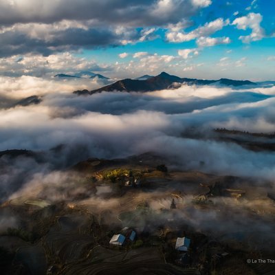 Bức ảnh chụp phong cảnh buổi sáng tại Sa Pa với những ruộng bậc thang trên cao nguyên và mây phủ quanh núi. Cảnh vật mang lại cảm giác yên bình và thanh thản giữa thiên nhiên hùng vĩ.