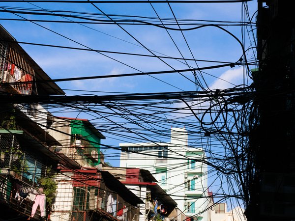 Bức ảnh chụp các dây điện chằng chịt phía trên các toà nhà chung cư trong một khu đô thị. Cảnh vật tạo cảm giác bình yên và phản ánh đời sống thường nhật ở thành phố.