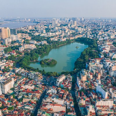 Ảnh chụp trên cao cho thấy Hồ Gươm nằm giữa trung tâm thành phố Hà Nội với các toà nhà cao tầng và khu phố cổ bao quanh. Cảnh quan mang lại cảm giác yên bình và hài hoà giữa thiên nhiên và đô thị.