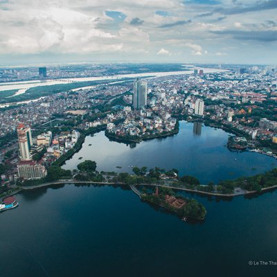 Ảnh chụp từ trên cao cho thấy Hồ Tây và Hồ Trúc Bạch nằm trong khu vực đô thị Hà Nội với nhiều toà nhà cao tầng và cây xanh bao quanh. Khung cảnh mang lại cảm giác yên bình và rộng lớn của thành phố thủ đô.