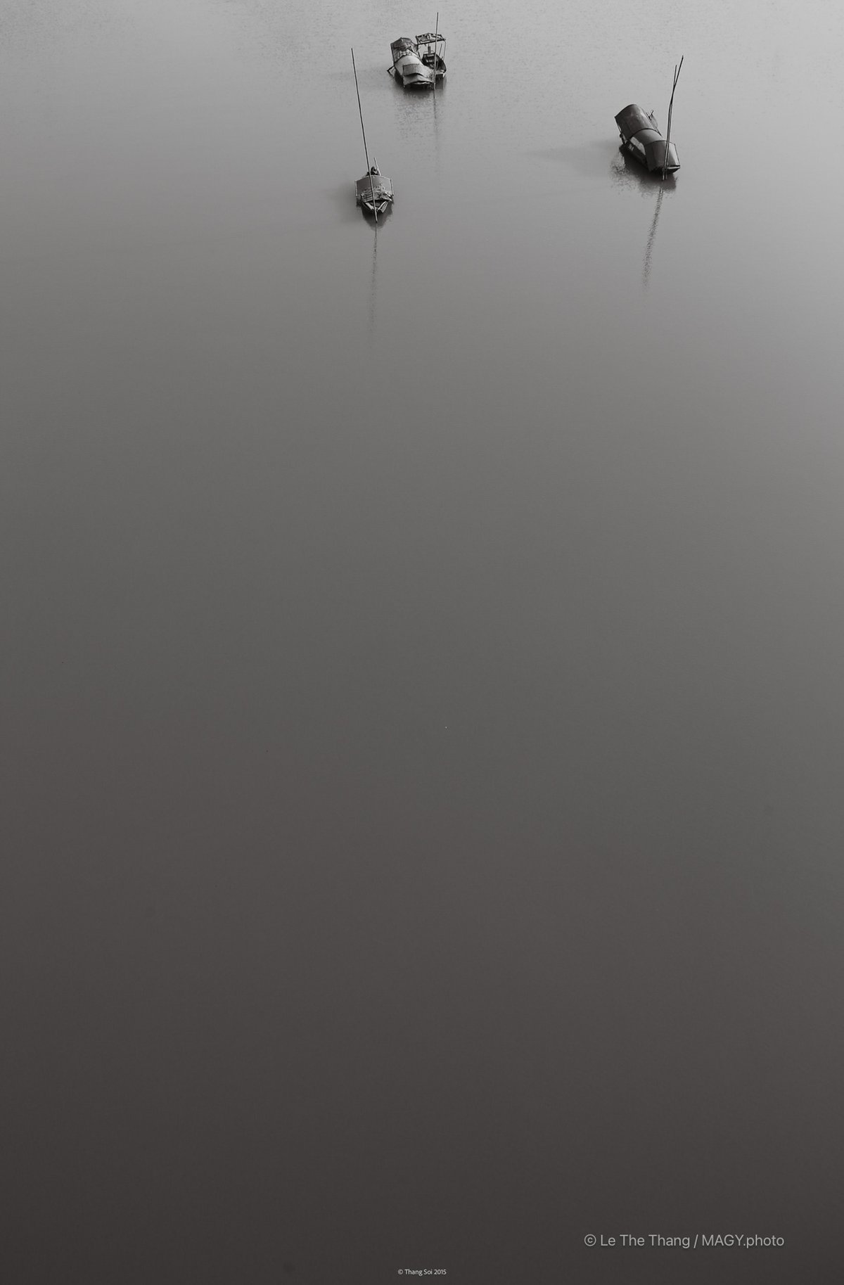 Bức ảnh chụp ba chiếc thuyền nhỏ trên mặt sông rộng lớn với tông màu đen trắng. Cảnh vật tạo cảm giác yên bình và tĩnh lặng, mang đến sự đơn giản và thanh thoát.