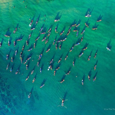 Hình ảnh chụp từ trên cao cho thấy nhiều tàu cá tụ tập trên vùng biển trong xanh tại chợ cá Tam Tiến, Quảng Nam. Không khí yên bình và truyền thống của một chợ cá miền Trung hiện lên rõ nét qua cảnh tượng này.