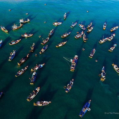 Ảnh chụp từ trên cao cho thấy nhiều tàu cá neo đậu trên vùng biển gần chợ cá Tam Tiến, Quảng Nam. Không khí sôi động và nhộn nhịp của một chợ cá truyền thống miền Trung được tái hiện rõ nét qua hình ảnh này.