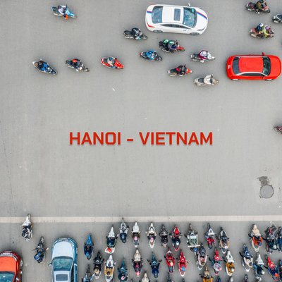 Hình ảnh chụp từ trên cao cho thấy giao thông đông đúc với nhiều xe máy và ô tô trên đường phố Hà Nội. Cảnh tượng này tạo cảm giác sống động và nhộn nhịp của cuộc sống đô thị Việt Nam.