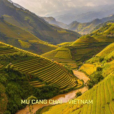 Bức ảnh thể hiện cảnh ruộng bậc thang ở Mù Cang Chải với những ngọn đồi xanh và vàng xen kẽ, có dòng sông chảy qua. Toàn cảnh mang lại cảm giác yên bình và hài hoà với thiên nhiên.