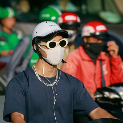 Bức ảnh chụp một nhóm người đàn ông đi xe máy trên đường phố thành phố vào buổi chiều nắng. Hình ảnh tạo cảm giác năng động và hiện đại trong cuộc sống đô thị.