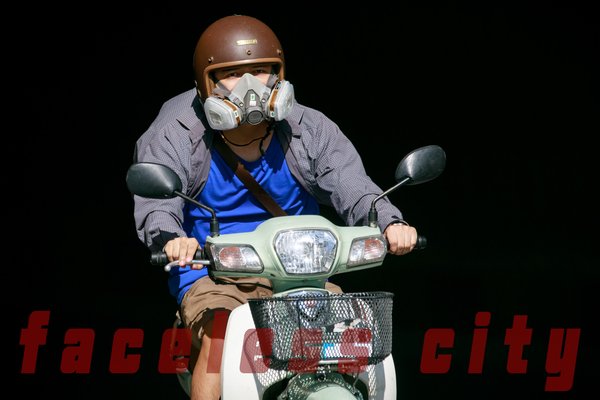 Hình ảnh một người đàn ông đội mũ bảo hiểm và đeo khẩu trang bảo hộ khi đi xe máy trong không gian đô thị. Bức ảnh thể hiện sự quan tâm đến việc bảo vệ sức khoẻ trước ô nhiễm không khí.